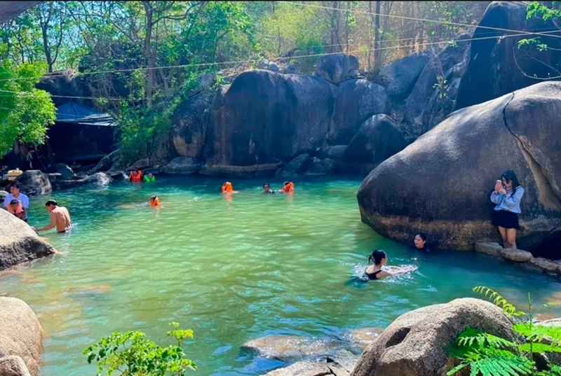 Suối Tiên là điểm dừng nổi bật trong hành trình Trekking Núi Dinh với dòng nước len qua những khối đá lớn giữa rừng xanh